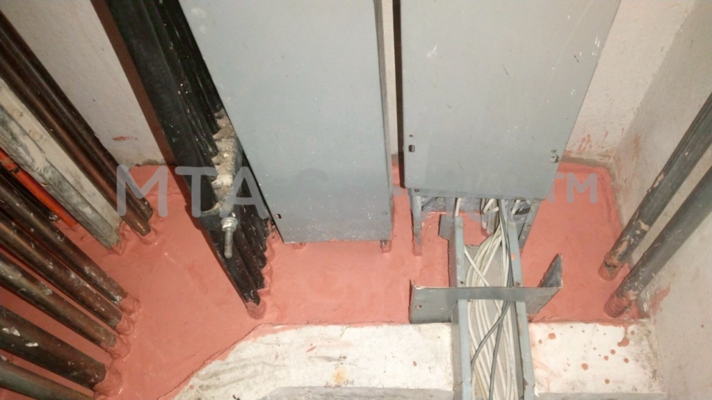 ช่างใช้เกรียงปาดหน้าปูน Metacaulk FRK Mortar ให้เรียบสนิทรอบแนวสายไฟในช่องชาร์ป